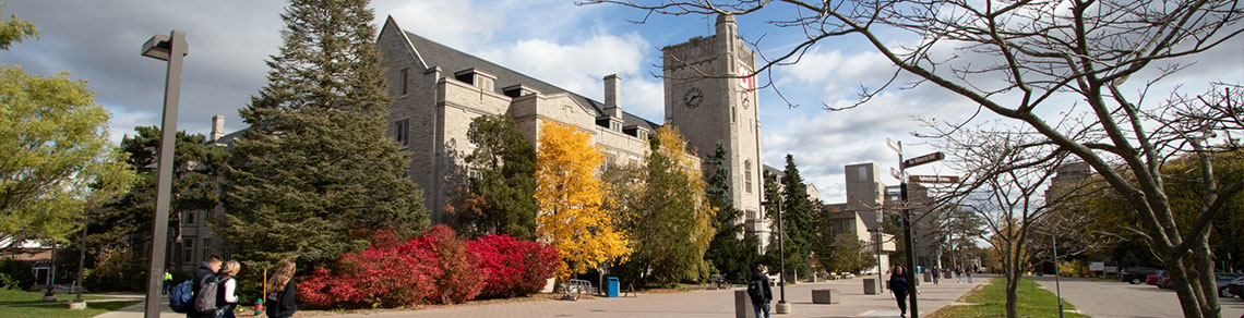 Image of walkway and colourful fall trees in front of Johnston Hall on campus